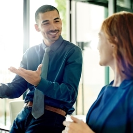 Two people talking to each other in a conference room