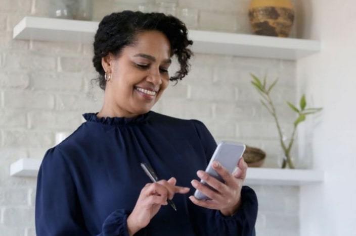 Woman using her cell phone to pay a bill.